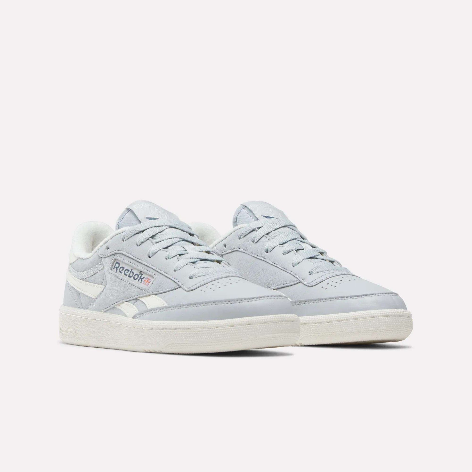 A pair of Women's Club C Revenge Shoes by Reebok in light gray, featuring white soles and white accents, are displayed on a plain white background—offering the perfect blend of vintage court style and casual women's footwear.