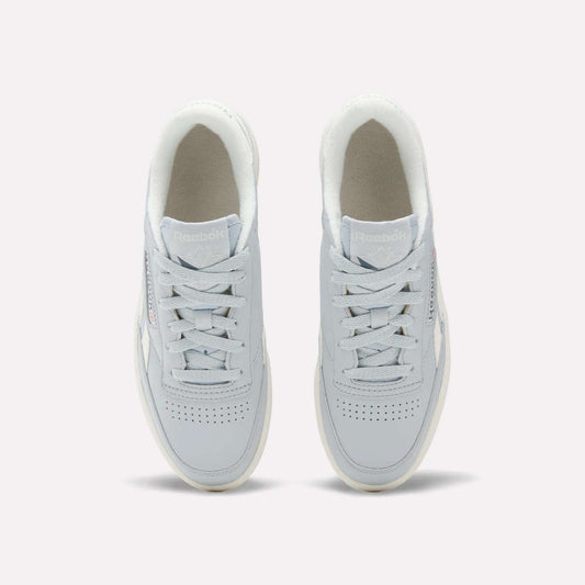 Top view of a pair of Reebok Women's Club C Revenge Shoes in light gray, featuring white soles and laces, placed side by side on a plain background. These casual shoes showcase vintage court style for a timeless look.