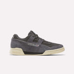 The Reebok Workout Plus Shoes in Black/Black/Paperwhite feature a vintage-inspired design with suede uppers, off-white soles, and classic Reebok branding on the side and heel, shown against a plain white background.