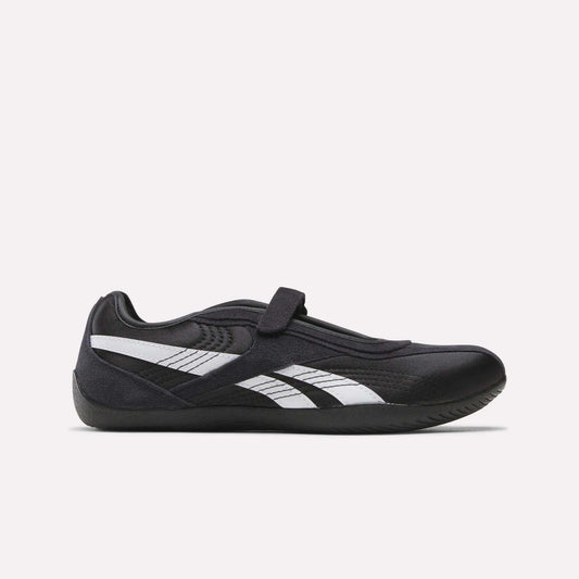 The Reebok Women's Ultra Lo Mary Jane Shoes are black low-profile runners with a single Velcro strap and white side stripes, shown in profile on a plain light background.
