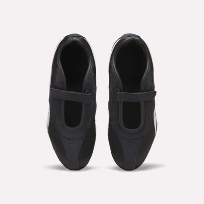 Top view of Reebok Women's Ultra Lo Mary Jane Shoes in black, featuring a single velcro strap on each, displayed side by side on a plain white background.