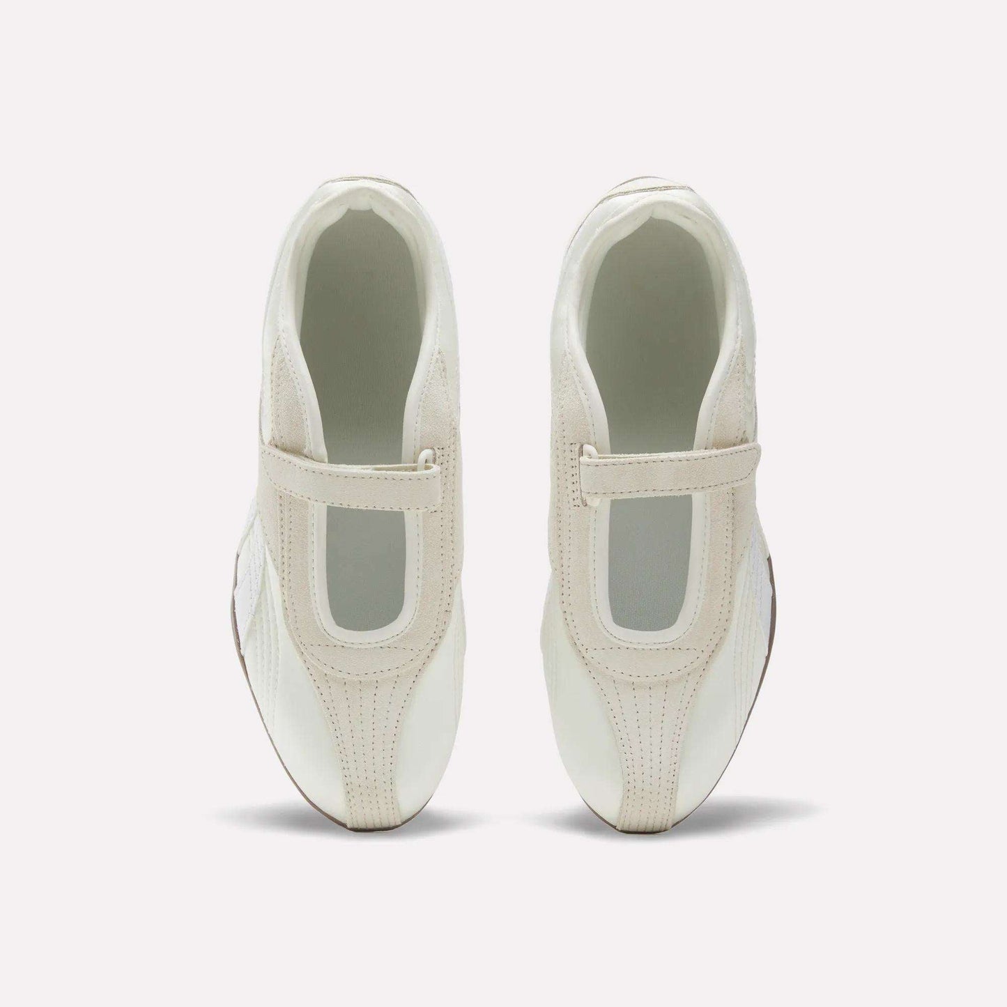 The Reebok Women's Ultra Lo Mary Jane Shoes are white slip-ons with beige accents and a wide elastic top strap, shown from above on a plain white background.