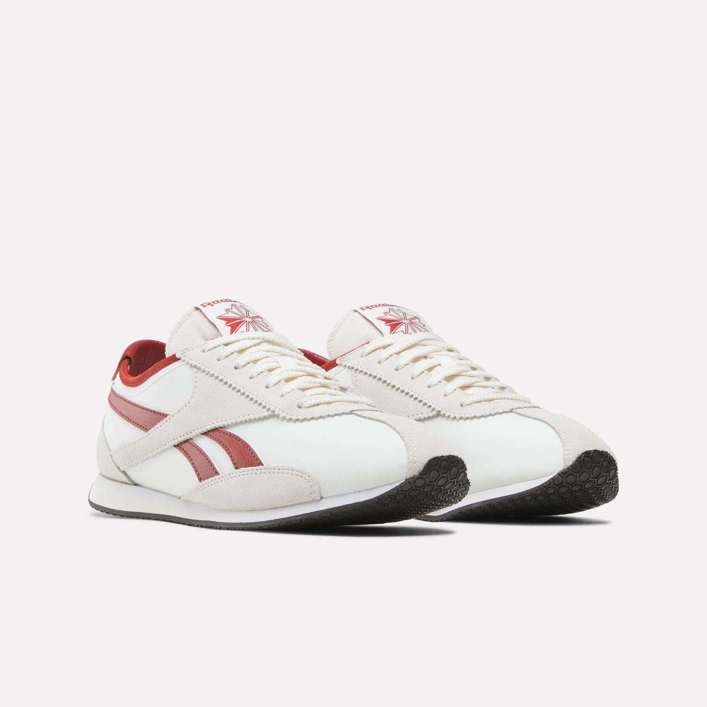 Introducing the Reebok R400 Shoes—a pair of white retro sneakers with red stripes and detailing, featuring a lace-up front and black rubber soles, displayed against a plain white background.
