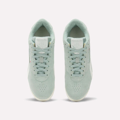 A pair of Women's Freestyle Lo Shoes by Reebok in light green suede are shown from above, displaying the tops, laces, tongues with Reebok logos, and placed side by side on a plain white background.