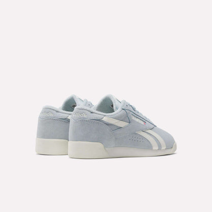 Women's Freestyle Lo Shoes by Reebok, in light blue with suede accents, white soles, and side stripes, are shown from the back and side on a plain white background.