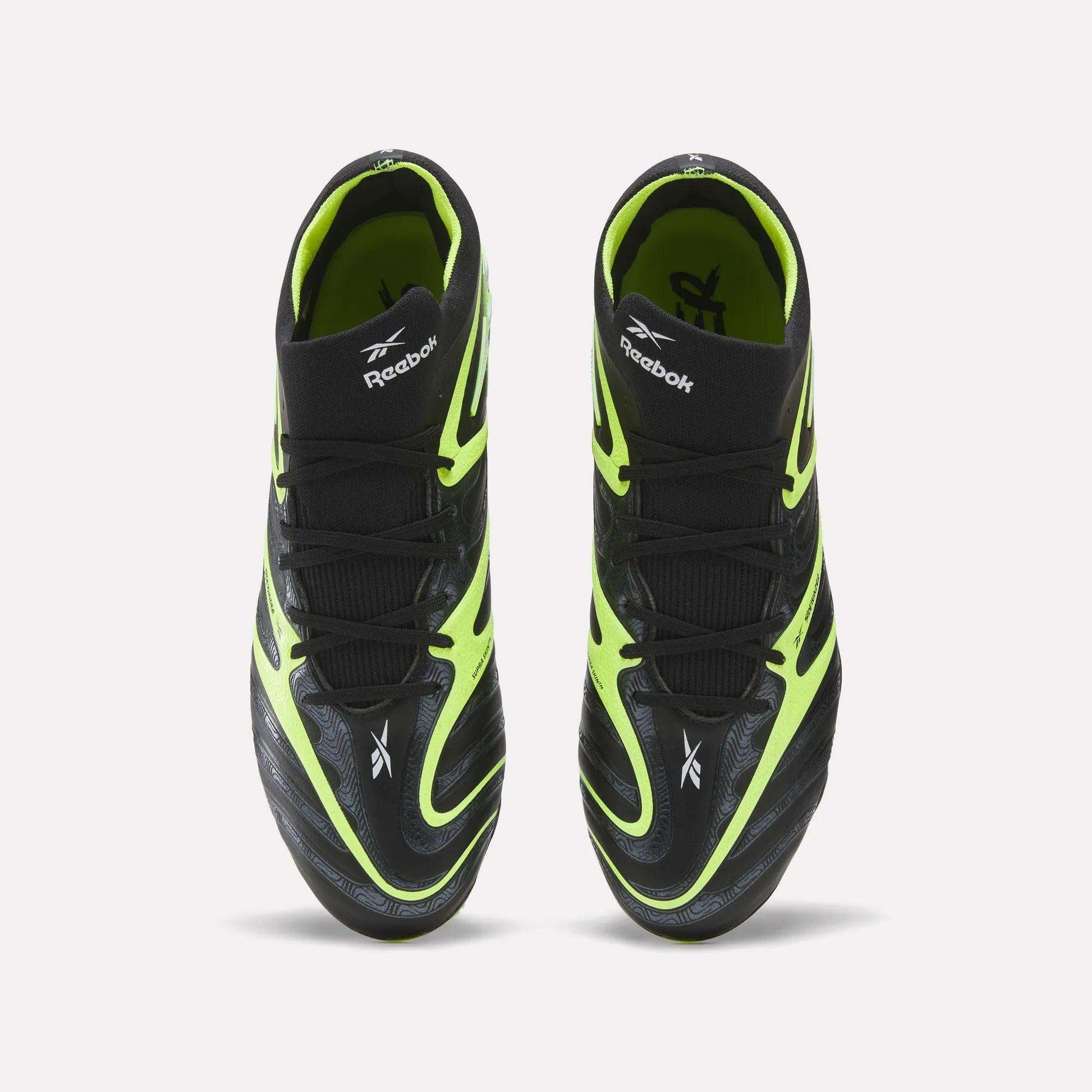 A pair of Reebok Sidewinder 26 Elite FG Cleats, shown from above, with black uppers, neon yellow accents, and white logos—designed for firm ground play and superior ball control.
