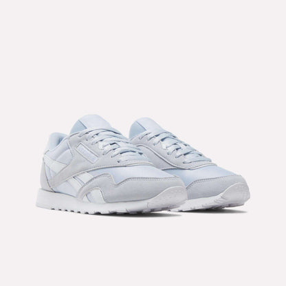 A pair of Reebok Women's Classic Nylon Shoes in light gray and white, featuring suede and mesh accents, white laces, and a white rubber sole, displayed on a plain white background.