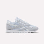 The Reebok Women's Classic Nylon Shoes in Tranquil Blue and White feature a timeless design with a lace-up front, white midsole, and durable rubber outsole—an ideal addition to any women's shoe collection, showcased against a plain white background.