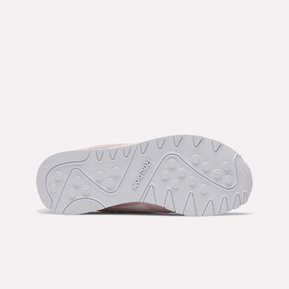 The image features the white rubber outsole of the Reebok Women's Classic Nylon Shoes, displaying a textured pattern with the Reebok logo embossed at the center and showcasing the stylish design from Reebok.