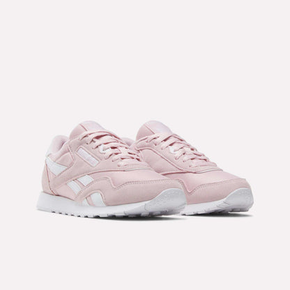 A pair of Women's Classic Nylon Shoes by Reebok in light pink, featuring white soles and white Reebok logo accents, displayed on a plain white background.