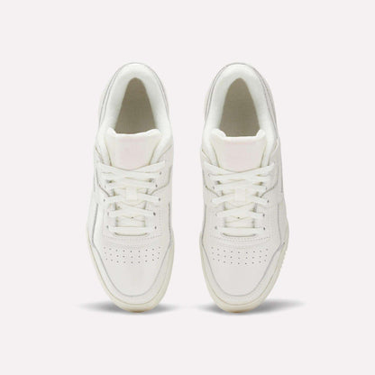 The Reebok Women's Workout Plus Shoes in white are shown from above, highlighting laces, stitching, and perforated toe boxes for classic '80s fitness style against a plain light background.
