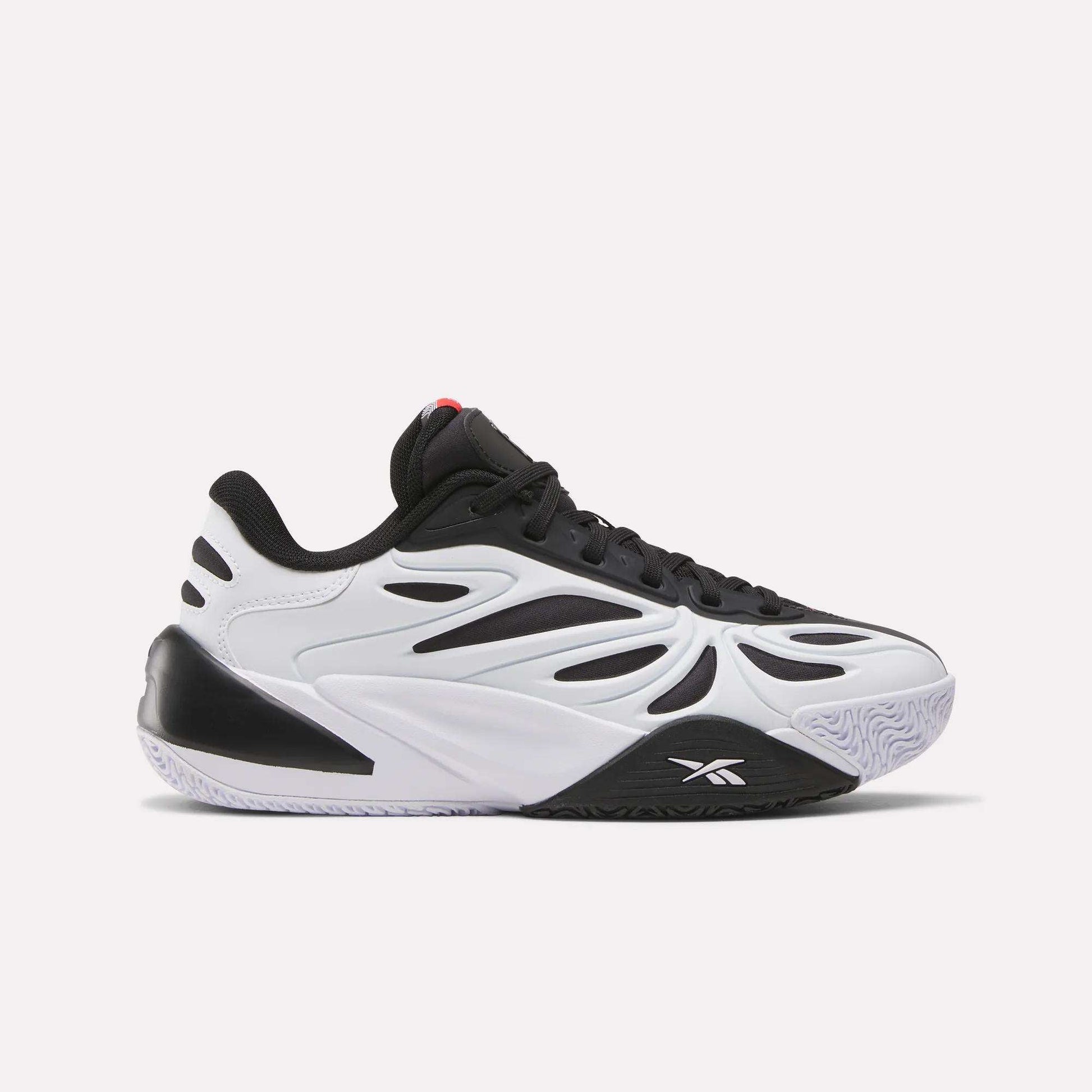 The Reebok Angel Reese 1 Shoes - Big Kids feature a stylish black and white design with a wavy side pattern, textured sole, and black laces, inspired by Angel Reese sneakers and shown in side profile on a plain white background.