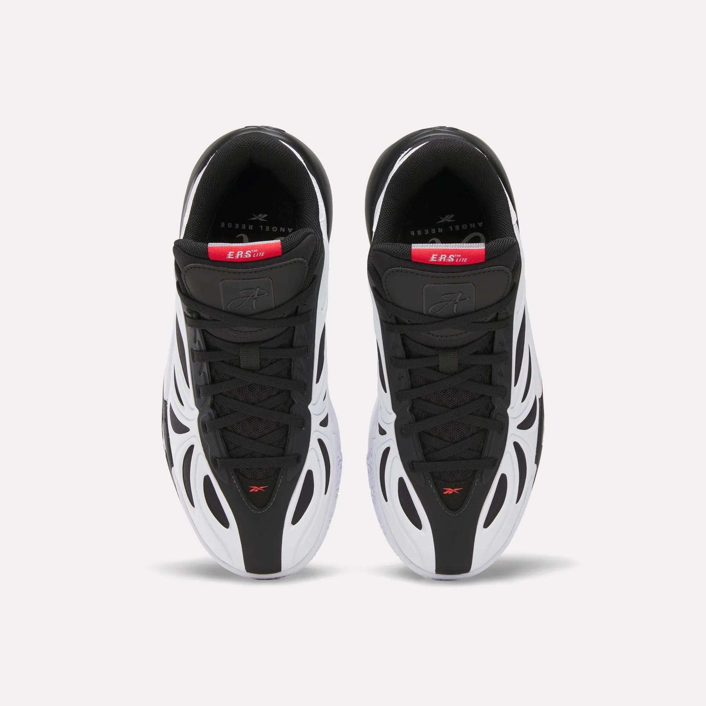 Top view of Reebok Angel Reese 1 Shoes for big kids in black and white with red and gray accents, wavy white side overlays, sleek design, and branded insoles with visible text near the heel.