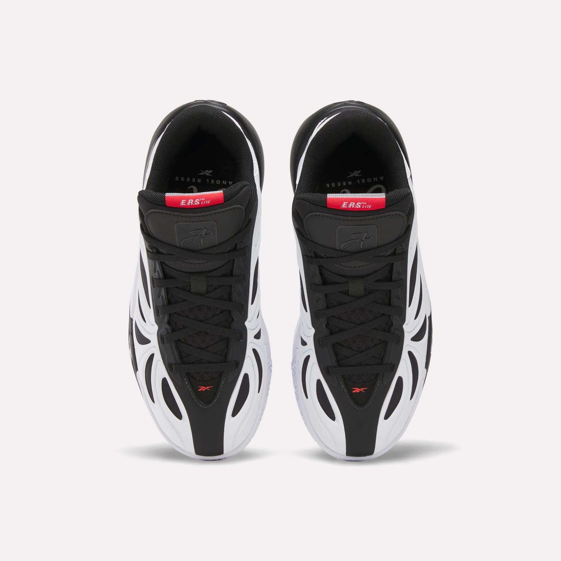 Top view of Reebok Angel Reese 1 Shoes for big kids in black and white with red and gray accents, wavy white side overlays, sleek design, and branded insoles with visible text near the heel.
