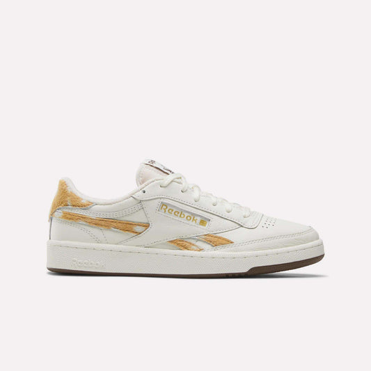 The Reebok Club C Revenge Vintage Shoes in Chalk/Chalk/Brown feature a white leather upper, tan fur accents, and tan and navy logo details. Displayed in a side profile against a plain light background, these tennis-inspired sneakers elevate classic Reebok style with a vintage touch.