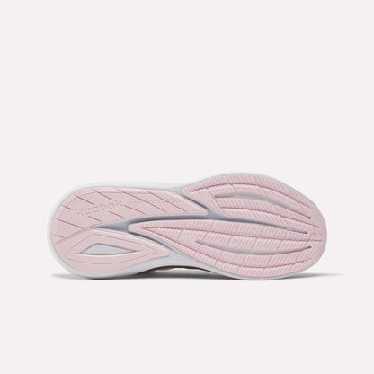 The image displays the sole of Reebok Women's Viva Speed Shoes, viewed from below. The outsole is mainly light pink with white accents, featuring wavy grooves and a textured tread for grip, offering extra cushioning and comfort.