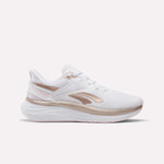 The Reebok Women's Viva Speed Shoes feature a white design with metallic rose gold accents and a thick, cushioned sole, displayed in a side profile against a plain white background.