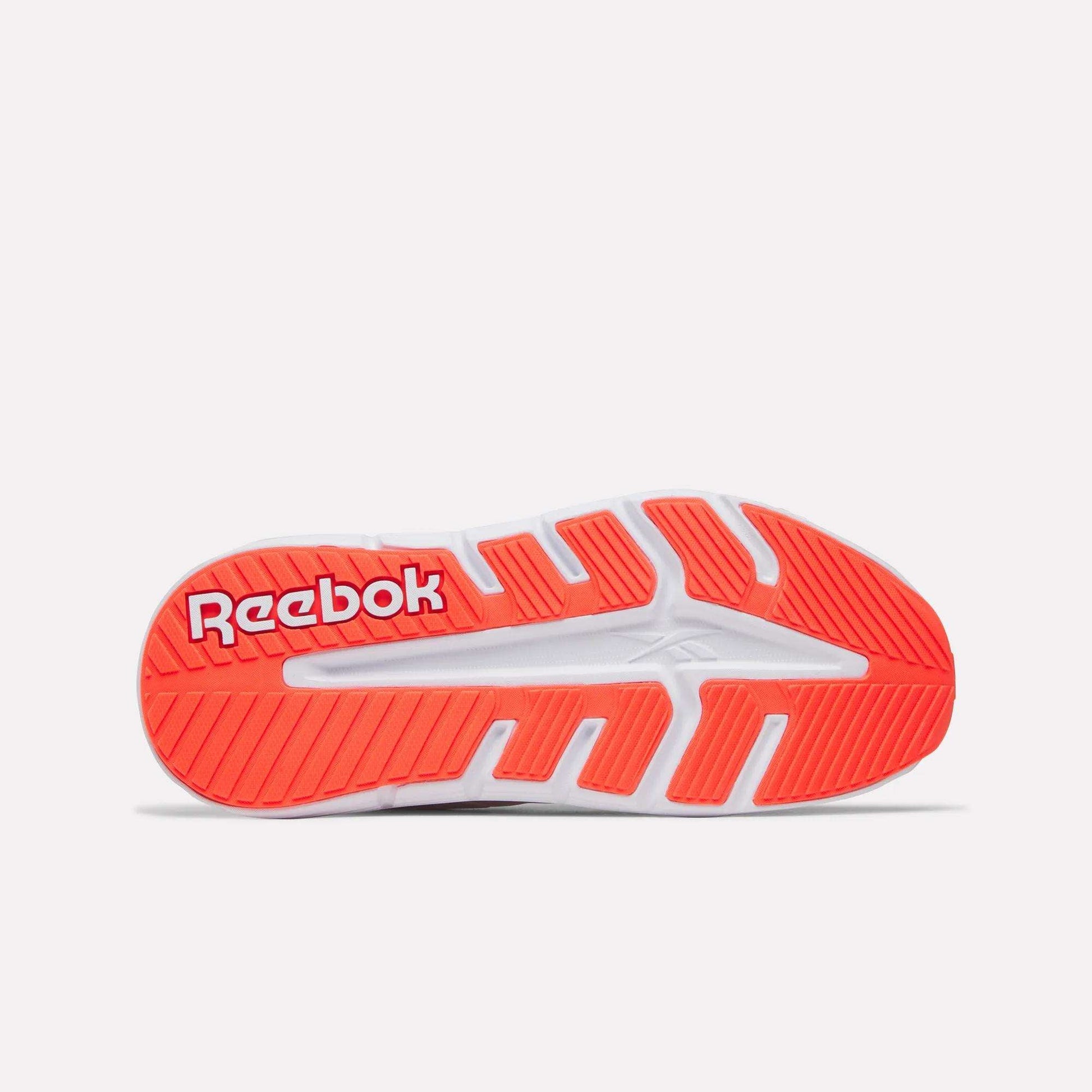 The image displays the sole of the Women's Nano Gym 2.0 Training Shoes by Reebok, mainly white with vibrant red and orange accents, featuring the bold white Reebok logo on a red background near the heel.