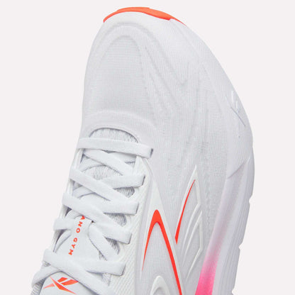 Close-up of the Reebok Women's Nano Gym 2.0 Training Shoes in white, with red and orange accents, a textured upper, white laces, cushioned sole with pink at the midsole—perfect for training.