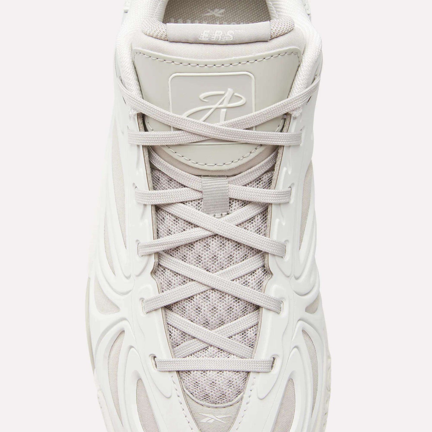 Top view of the Reebok Angel Reese 1 Basketball Shoes in white with textured mesh, light gray laces, molded side design, a stylized tongue logo, and Energy Return System for enhanced basketball performance.