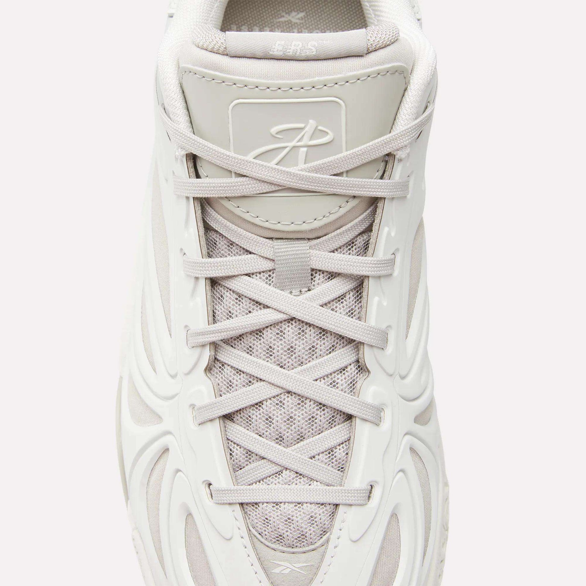 Top view of the Reebok Angel Reese 1 Basketball Shoes in white with textured mesh, light gray laces, molded side design, a stylized tongue logo, and Energy Return System for enhanced basketball performance.