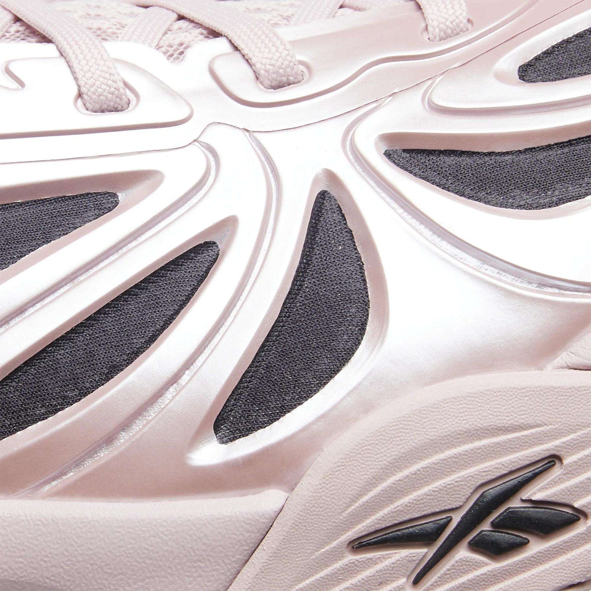 Close-up of a light pink Angel Reese 1 Basketball Shoe by Reebok, featuring sculpted raised details, black mesh underlays, a visible Reebok logo, and the Energy Return System inspired by performance basketball shoes.