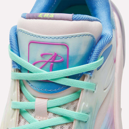 Close-up of the Reebok Angel Reese 1 Basketball Shoes, featuring turquoise laces, a pastel blue and pink tongue, mesh accents, and a stylized A logo on a purple-blue patch—all in a soft gradient pastel color scheme.
