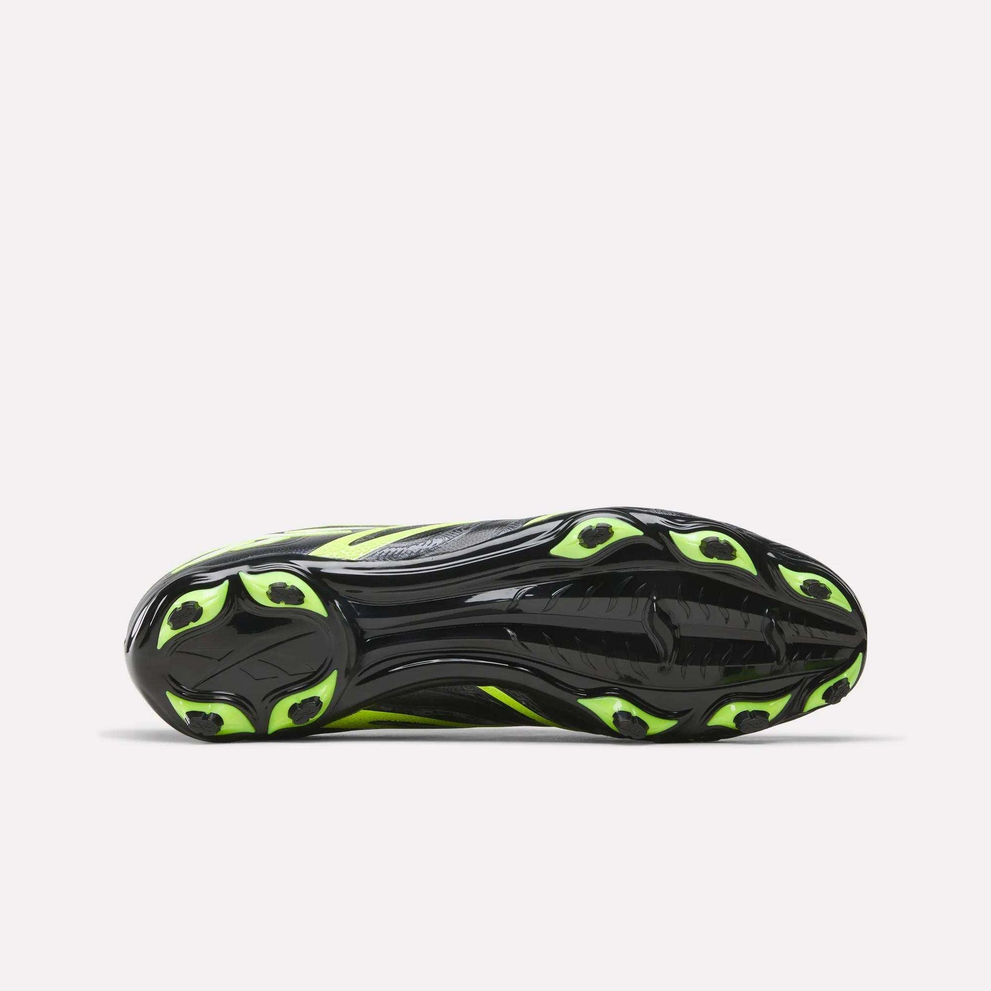 The image shows the sole view of the Reebok Sidewinder 26 League Firm Ground Soccer Cleats, featuring a black sole with neon yellow accents and multiple firm ground studs for enhanced traction and ball control.