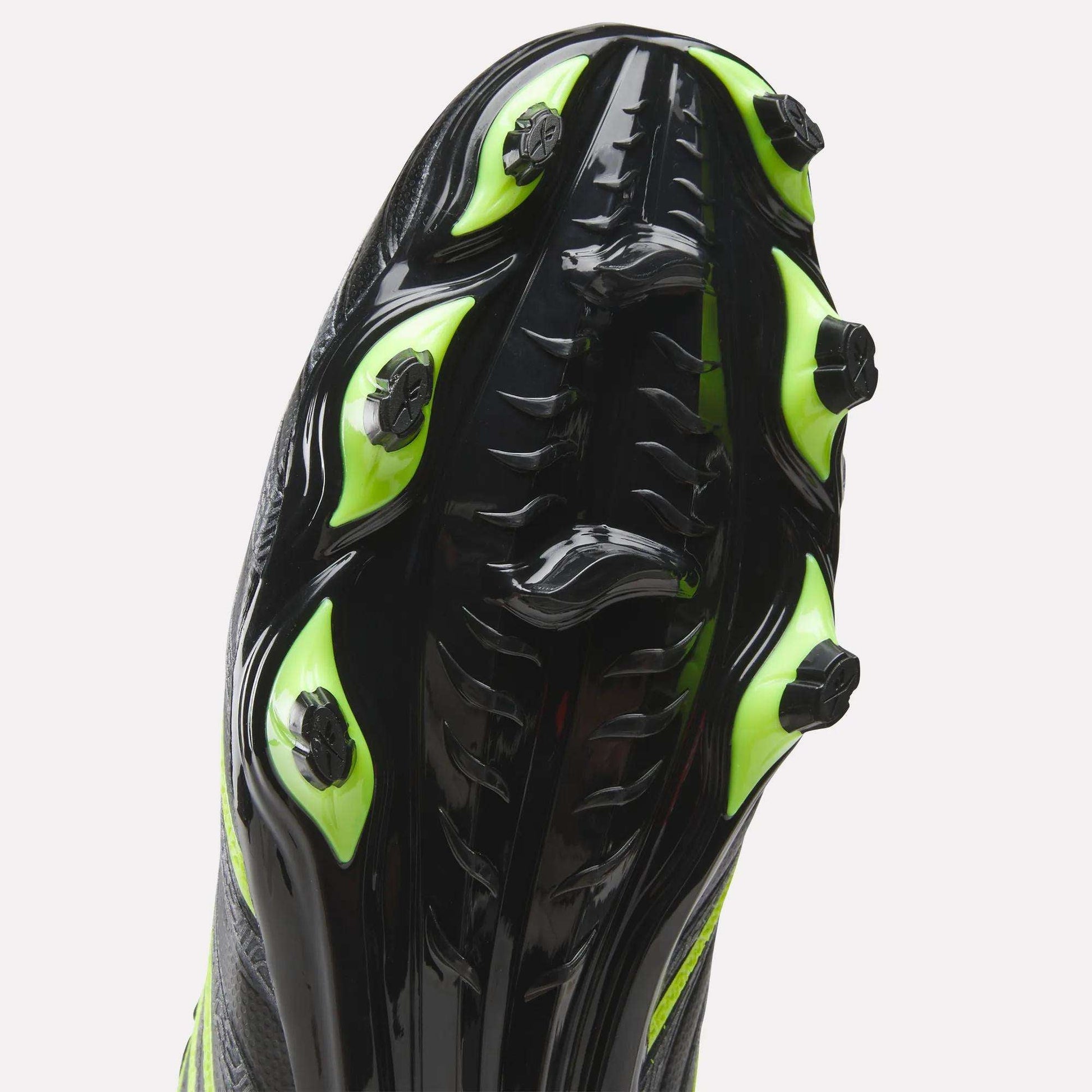 Close-up of the sole of Reebok Sidewinder 26 League Firm Ground Soccer Cleats in black with neon green studs, highlighting the traction pattern and design for enhanced ball control.