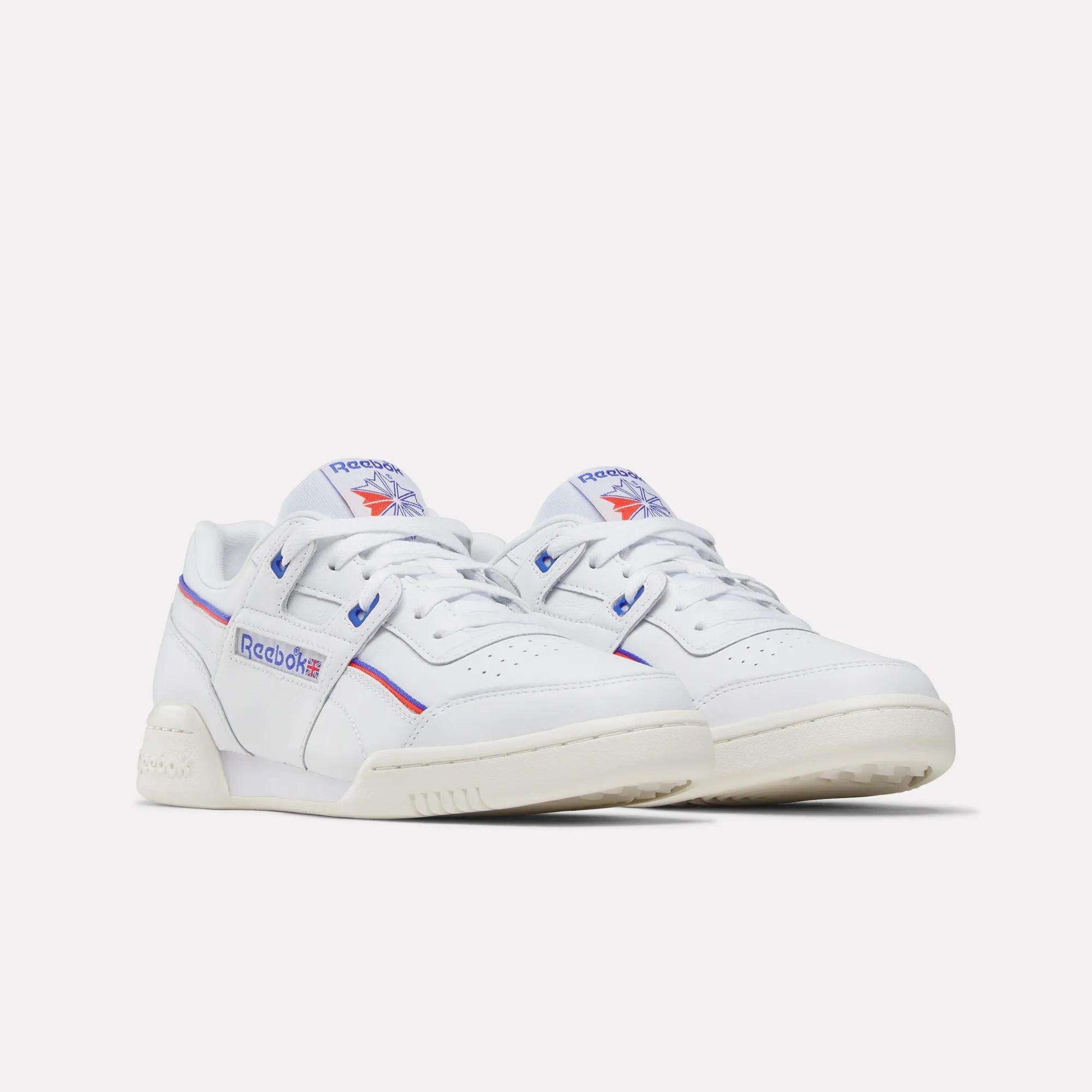 A pair of Reebok Women's Club C 85 Shoes in white leather with blue and red accents, featuring the Reebok logo on the sides and tongue, displayed against a plain white background—timeless style for any outfit.