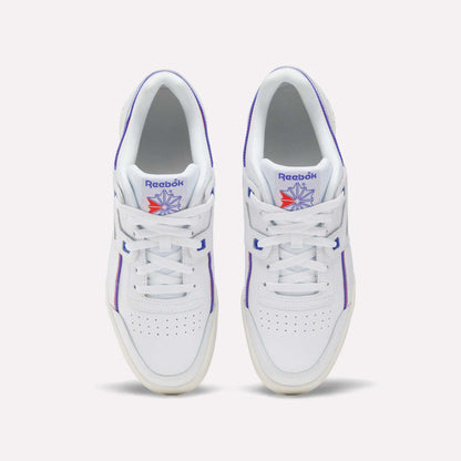 A pair of Women's Club C 85 Shoes by Reebok in white leather with purple accents and a blue and orange Reebok logo on the tongue, shown from above on a light background—classic women's sneakers with timeless style.