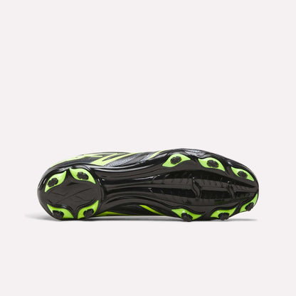 The image shows the sole of the Reebok Sidewinder 26 League FG Cleats for big kids, featuring a black base with neon yellow accents and several firm ground studs for dependable traction on the field.