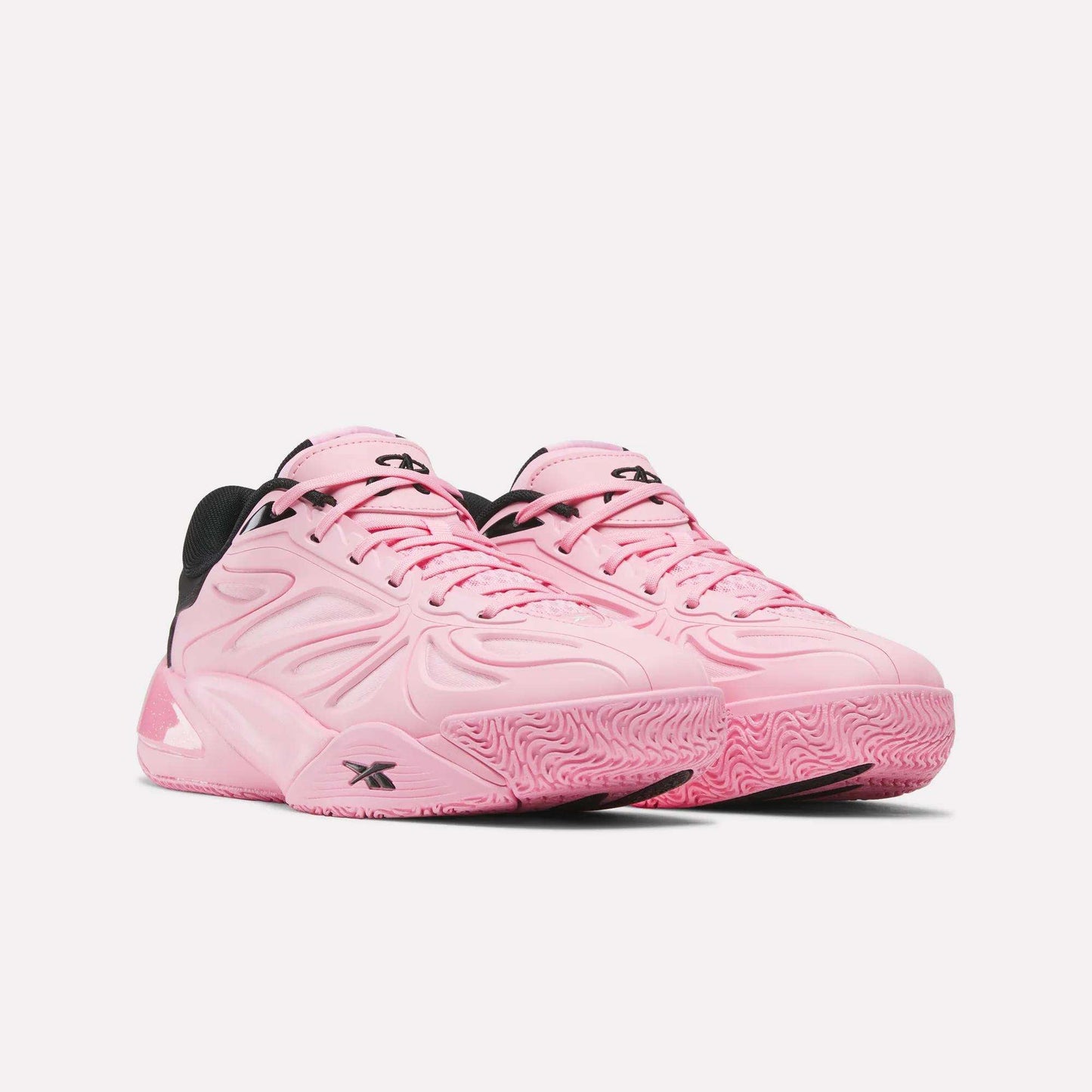 A pair of Reebok Angel Reese 1 Shoes in pink with black accents, textured details, and chunky soles featuring the innovative Reebok Energy Return System, displayed on a white background.