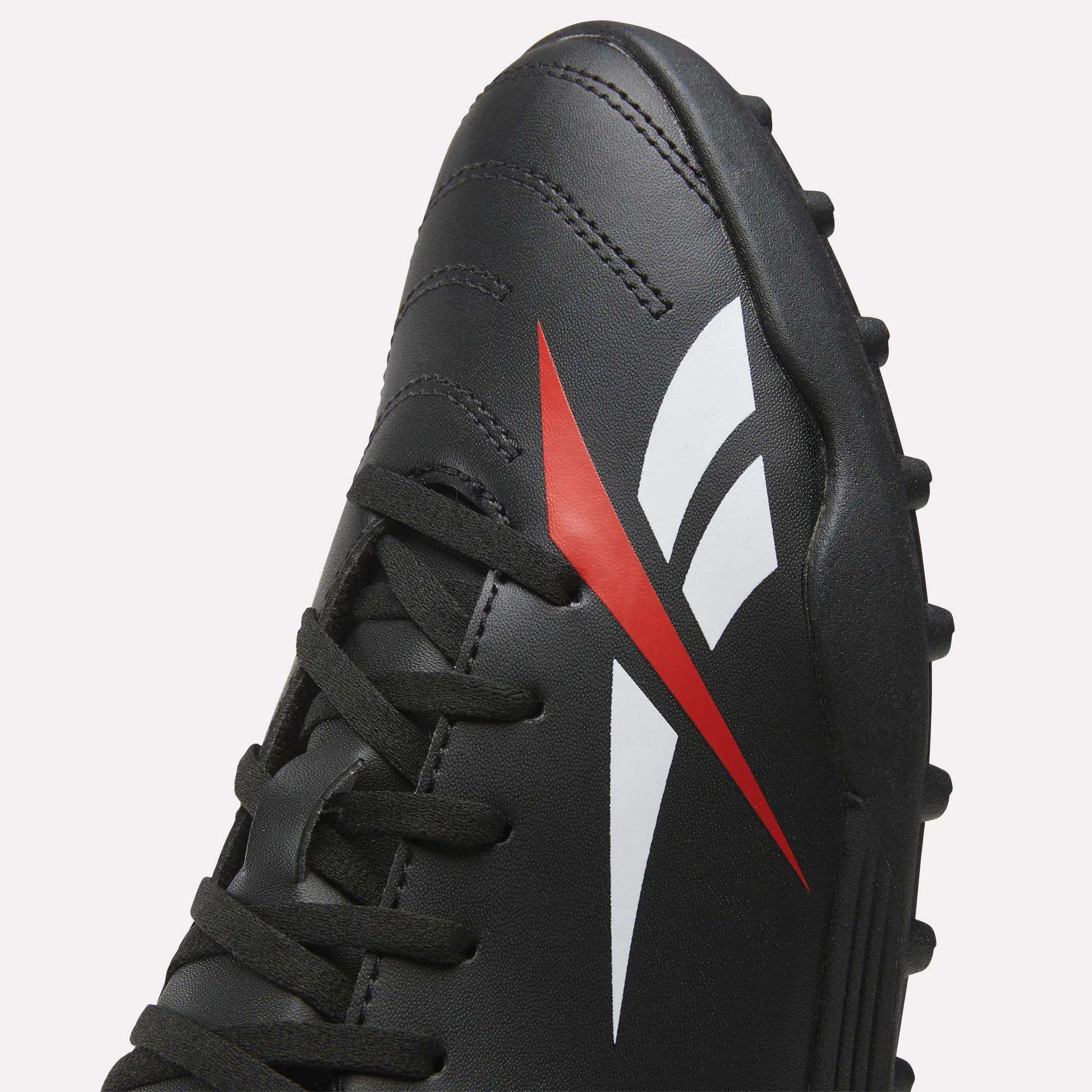 Close-up of the Reebok Strike Turf Soccer Shoes in black, featuring black laces and a distinctive red and white stylized logo on the side. These turf soccer shoes are designed for optimal performance on both turf and grass fields.