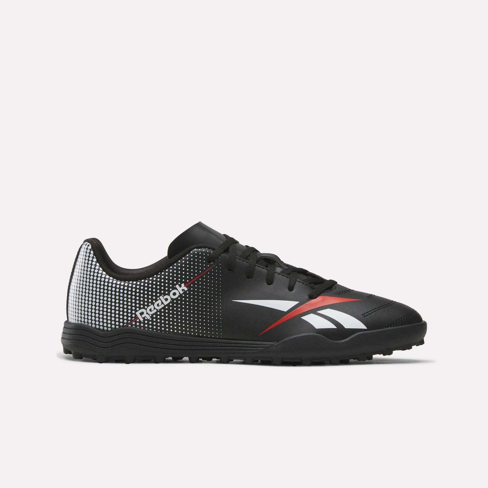 The Reebok Strike Turf Soccer Shoes in Black/Red feature white and red accents, a dotted pattern on the heel, and a white Reebok logo on the side. Shown against a plain white background, these stylish soccer shoes deliver both performance and flair—ideal for practice or playing on turf.