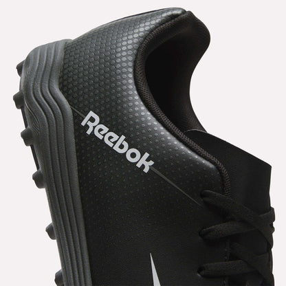 Close-up of a black Reebok Strike Turf Soccer Shoe featuring textured dots, a silver Reebok logo, and a gray cleated sole—ideal for soccer practice. Only part of the shoe and its laces are shown.