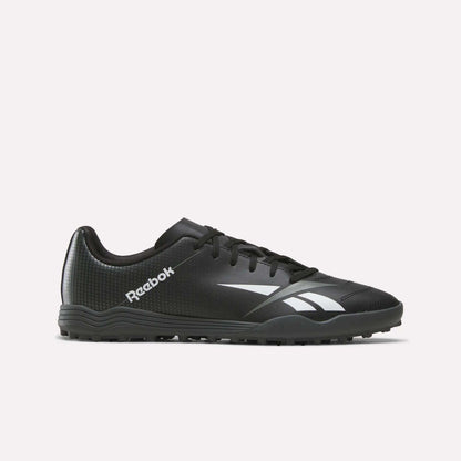 The Reebok Strike Turf Soccer Shoes in Black/White, featuring a white logo and accents, are designed for turf sports and perfect for soccer practice. Shown here is a side profile view on a plain white background.