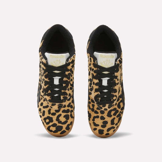 A pair of Reebok Women's Freestyle Lo Shoes with a bold leopard print pony hair upper, black laces and accents, and white tongues featuring the gold Reebok logo, inspired by classic '80s fitness trainers, viewed from above on a white background.