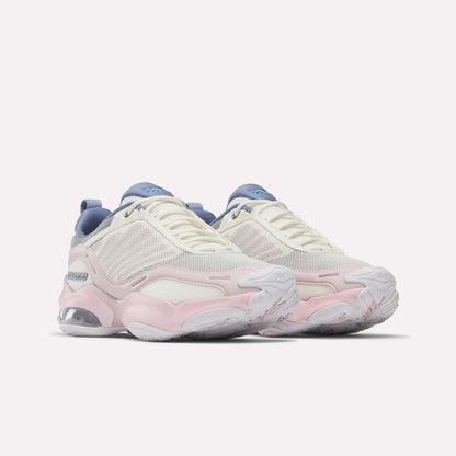 The Reebok Women's DMX Series 3000 Training Shoes feature white mesh uppers with light pink and beige accents, blue details on the tongue and heel, chunky white soles with visible air cushioning, and advanced DMX 3 Technology—offering cushioned comfort and support for a superior walking experience.