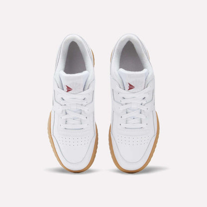 A top view of Reebok Workout Plus Ripple Shoes in white leather with gum soles, white laces, perforated toe boxes, and red Reebok logos on the tongues adds a subtle vintage touch.