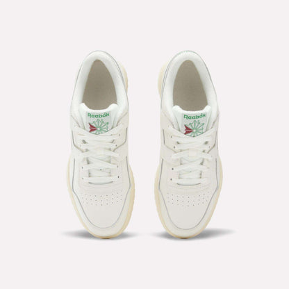 A pair of Reebok Workout Plus Ripple Shoes viewed from above, featuring green Reebok logos with a red and green design on the tongue, white laces, and cream-colored soles.