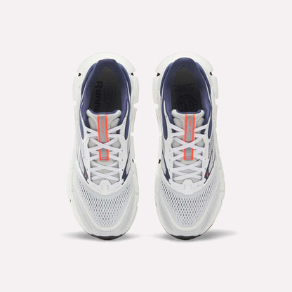 Top view of a pair of Reebok Men's FloatZig 2 Running Shoes with white mesh toes, navy interiors, Superfloat+ cushioning, and orange tongue branding, displayed side by side on a plain white background.