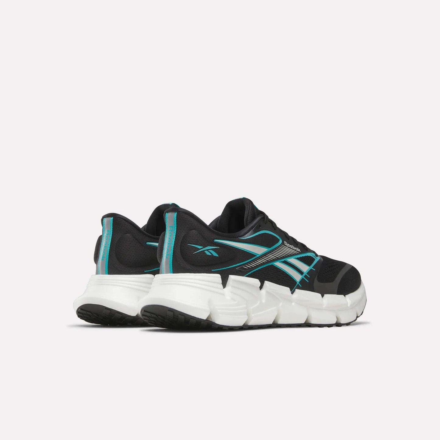A pair of Reebok Men's FloatZig 2 Running Shoes in black with teal accents and white chunky soles, featuring Superfloat+ cushioning, shown from the back and side on a plain light background.