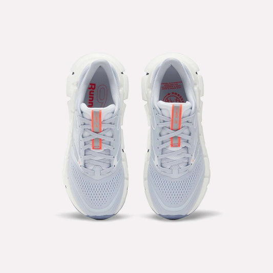Top view of Reebok Women's FloatZig 2 Running Shoes with light gray mesh uppers, Superfloat+ cushioning for a springy feel, white soles, and orange accents on the tongue and insole, placed side by side on a plain background.