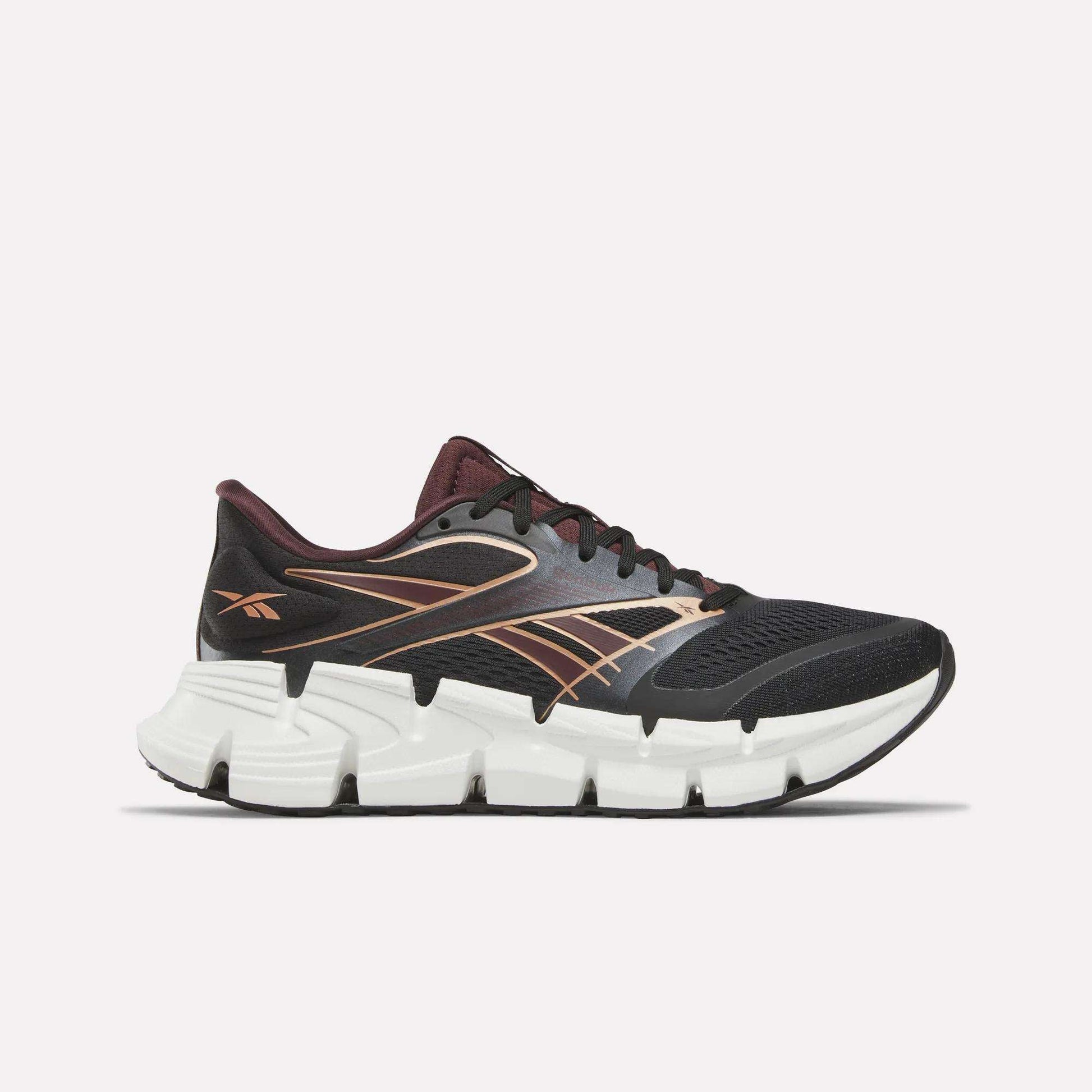 The Reebok Women's FloatZig 2 Running Shoes in Black/Metallic feature a breathable mesh upper and a cushioned Superfloat+ sole for comfort, with maroon and gold accents, shown against a plain white background.