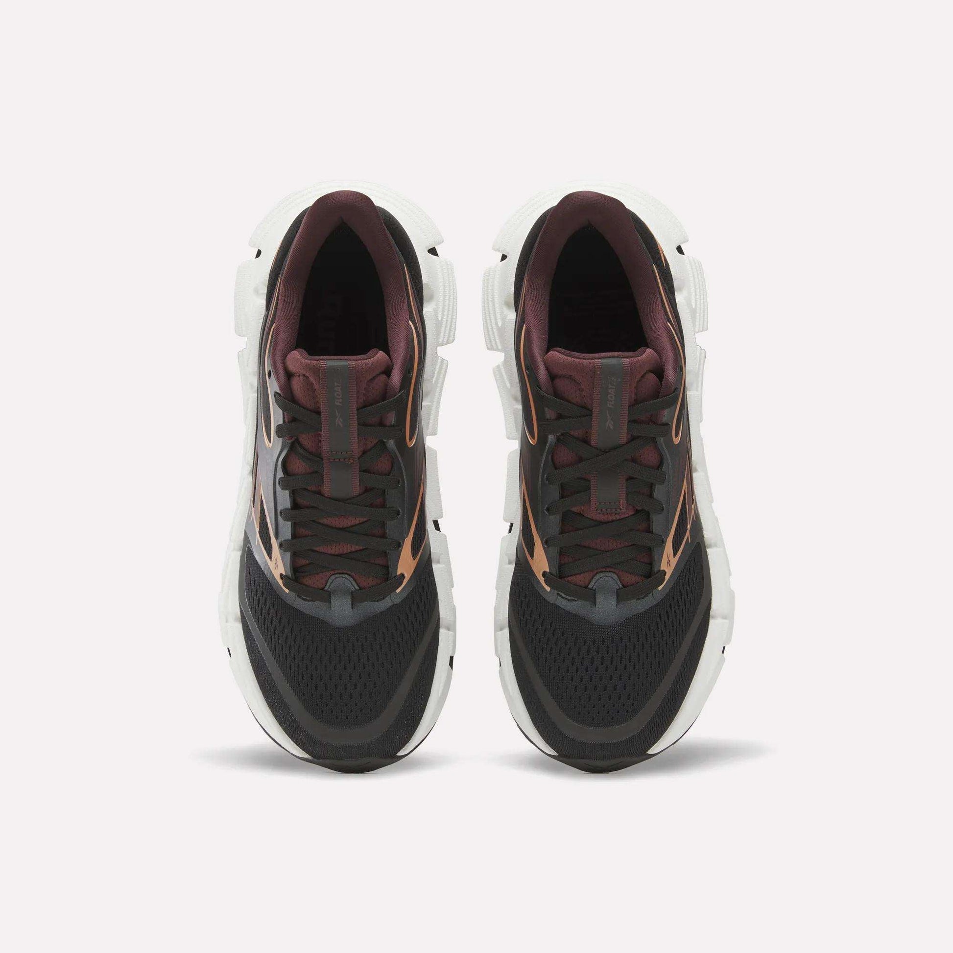 A pair of Reebok Women's FloatZig 2 Running Shoes seen from above, with black mesh toes, dark maroon tongues and collars, brown accents, and thick white Superfloat+ cushioned soles against a light background.