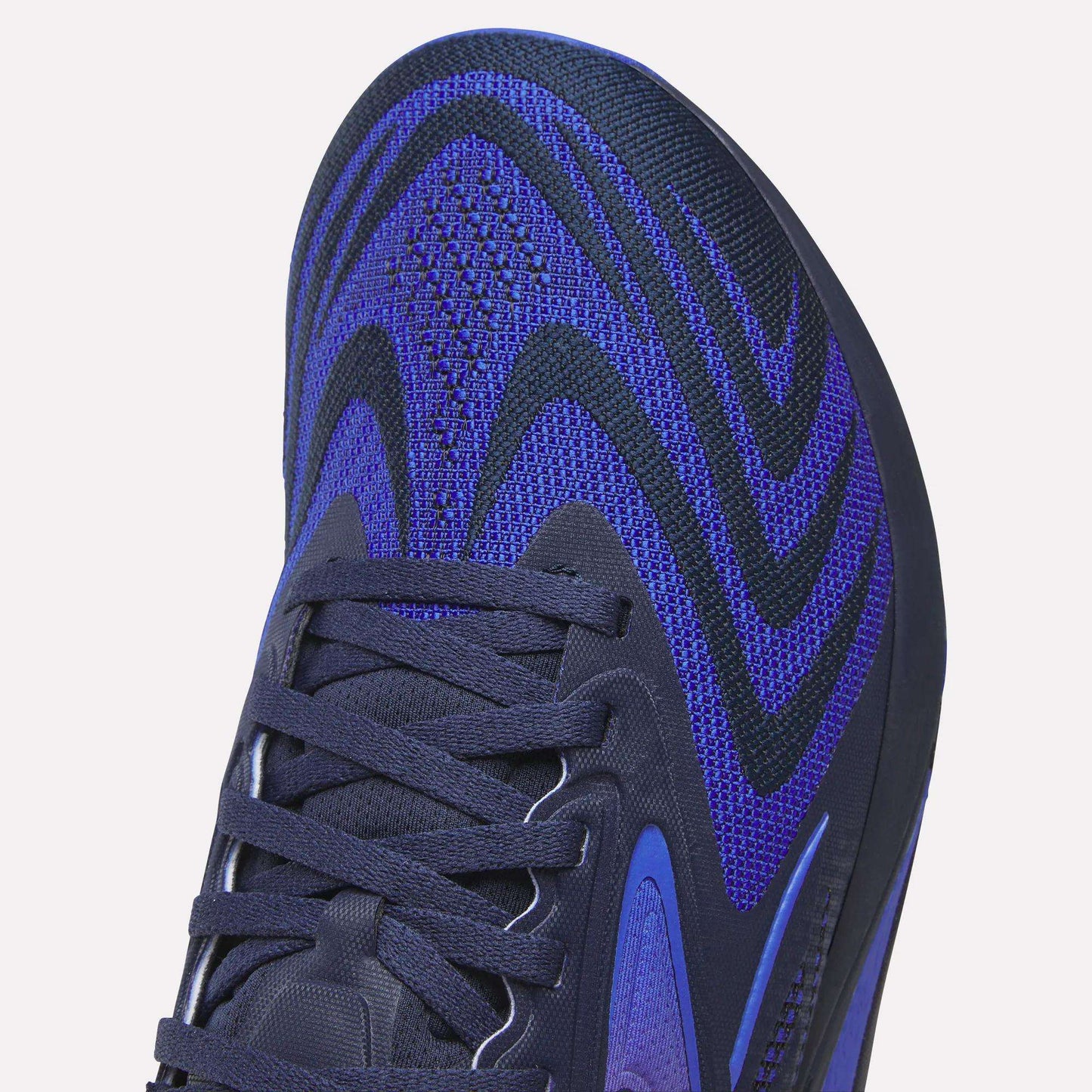 Close-up of the front and side of Reebok Nano X5 Edge Training Shoes showcasing a blue and black woven upper with black laces and a textured design—perfect for precision workouts.