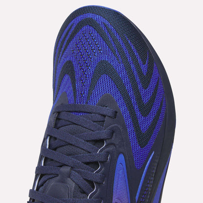 Close-up of the front and side of Reebok Nano X5 Edge Training Shoes showcasing a blue and black woven upper with black laces and a textured design—perfect for precision workouts.