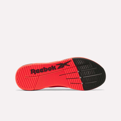 The image displays the sole of a Reebok Nano X5 Edge Training Shoe, featuring a mainly red base with a black toe section, horizontal grooves for performance, and "Reebok" plus its logo in black across the midsole.