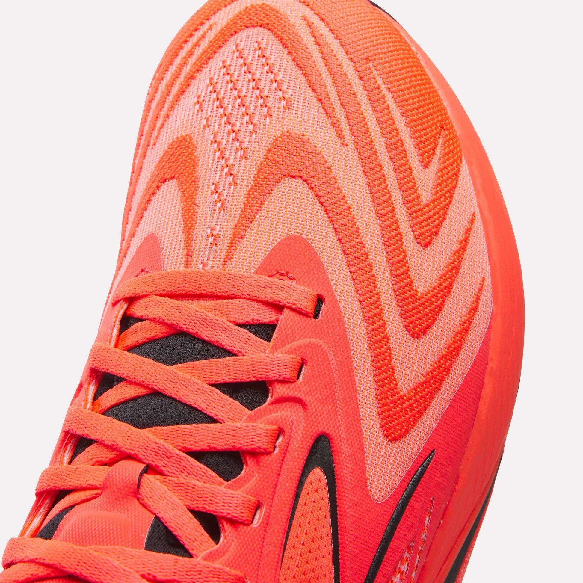 Close-up of the front and side of the Reebok Nano X5 Edge Training Shoes in bright orange, featuring wavy patterned stitching, black accents, and detailed laces and toe area for enhanced performance.